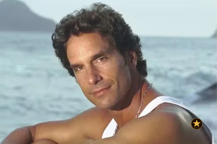 Um plano m&eacute;dio de Victor Fasano hoje, com seus cabelos grisalhos e camisa de linho em tons terrosos, posando em meio a uma vegeta&ccedil;&atilde;o nativa densa.