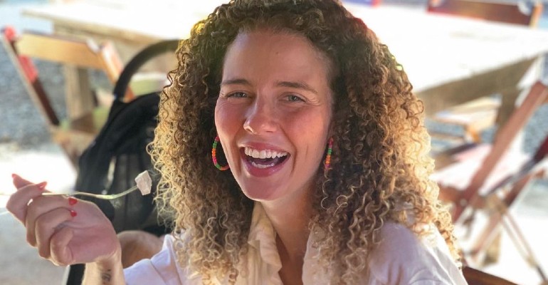 Debby Lagranha com cabelos presos, vestindo um uniforme de veterin&aacute;ria pr&aacute;tico