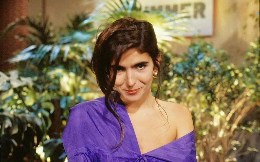 Um retrato em plano m&eacute;dio de Malu Mader em uma livraria de rua no Leblon.